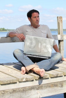 man-on-laptop-by-a-lake